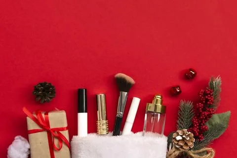 Flat lay composition with makeup products and Christmas decor on red paper .. Stock Photos