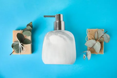 Flat lay composition with marble soap dispenser on light blue background Stockfoto's