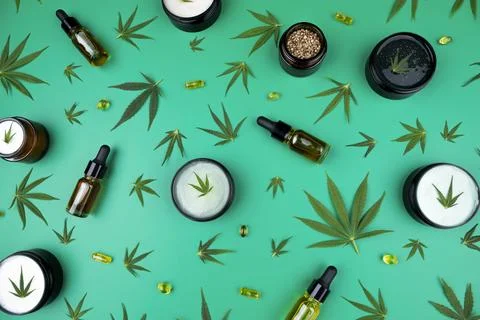 Flat lay composition of marijuana and hemp seeds on green color paper backg.. Fotos de archivo