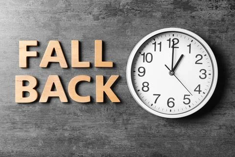 Flat lay composition with modern clock and words FALL BACK on grey background Stock Photos