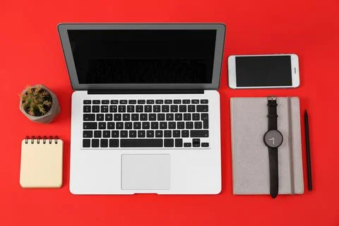 Flat lay composition with modern devices and office tools on red background Stock Photos