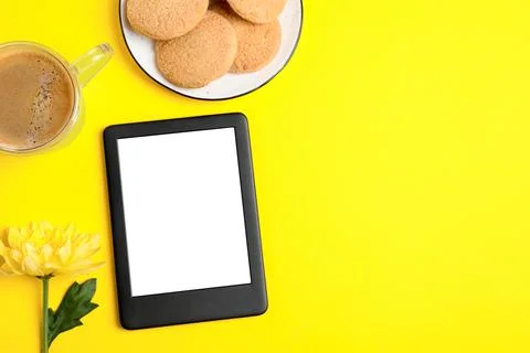 Flat lay composition with modern e-book reader on yellow background. Space fo Stock Photos
