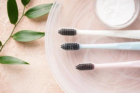 Flat lay composition of multi-colored toothbrushes with tooth powder on a bei Stock Photos