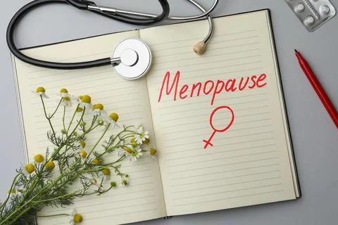 Flat lay composition of notebook with word Menopause and female gender sign o Stock Photos