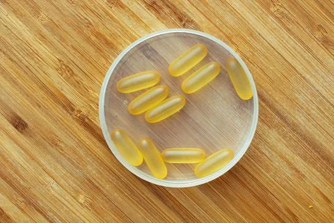 Flat lay composition of Omega 3 gel capsules on the wooden table Foto stock