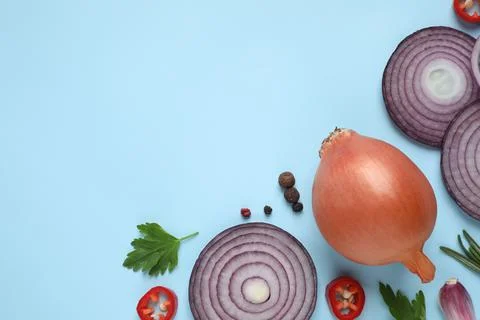 Flat lay composition with onion and spices on light blue background. Space fo Stock Photos