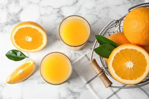 Flat lay composition with orange juice and fresh fruit on marble background Stock Photos