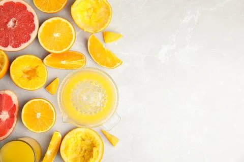 Flat lay composition with oranges and squeezer on light table. Space for text Stock Photos