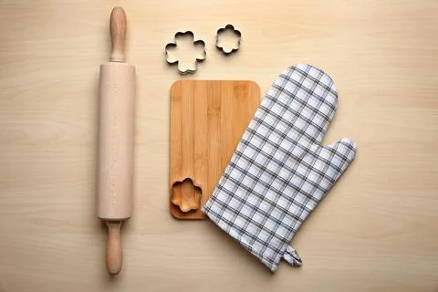 Flat lay composition with oven glove and kitchenware on wooden table Stock Photos