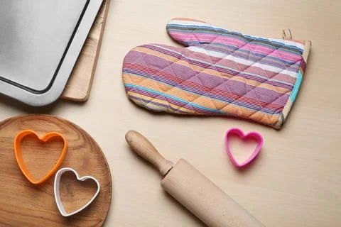 Flat lay composition with oven glove and kitchenware on wooden table Stock Photos