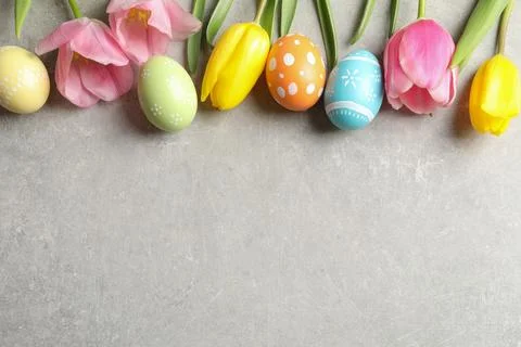 Flat lay composition of painted Easter eggs and flowers on color background,  Stock Photos