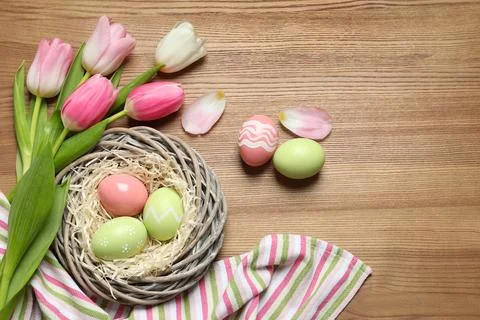 Flat lay composition with painted Easter eggs and tulips on wooden table, spa Stock Photos