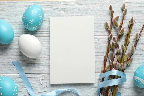 Flat lay composition with painted Easter eggs and blank card on wooden backgr Stock Photos