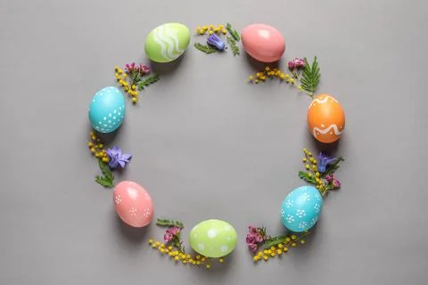 Flat lay composition of painted Easter eggs and flowers on color background,  스톡 사진
