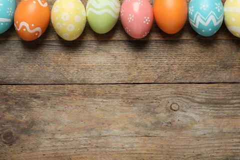 Flat lay composition of painted Easter eggs on wooden background, space for t Foto stock