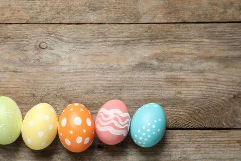 Flat lay composition of painted Easter eggs on wooden background, space for t Stock Photos