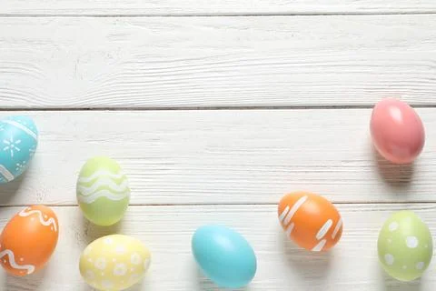Flat lay composition of painted Easter eggs on wooden background, space for t Stock Photos