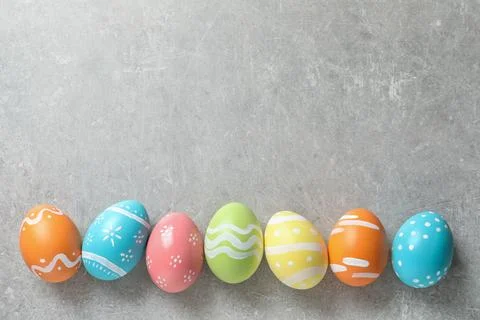 Flat lay composition of painted Easter eggs on color background, space for te Stock Photos