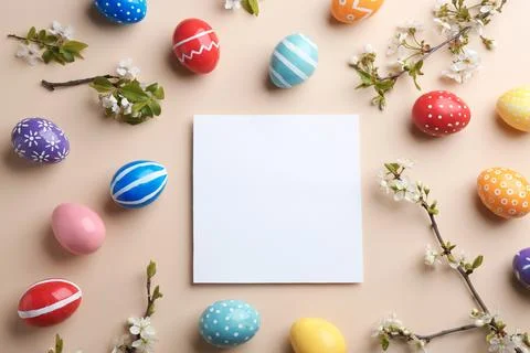 Flat lay composition with painted Easter eggs and blank card on color backgro Stock Photos