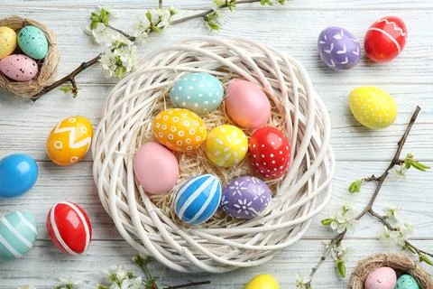 Flat lay composition with painted Easter eggs and blossoming branches on wood Stock Photos