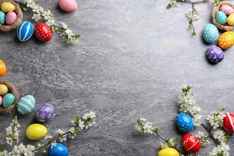 Flat lay composition with painted Easter eggs and blossoming branches on colo Stock Photos
