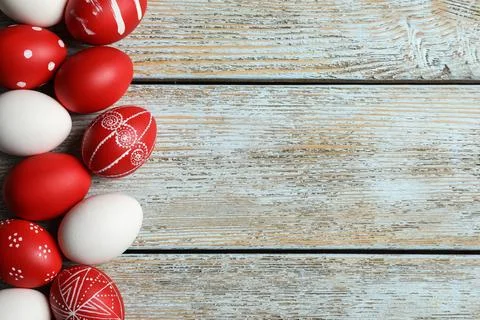 Flat lay composition of painted red Easter eggs on wooden table, space for te Stock Photos