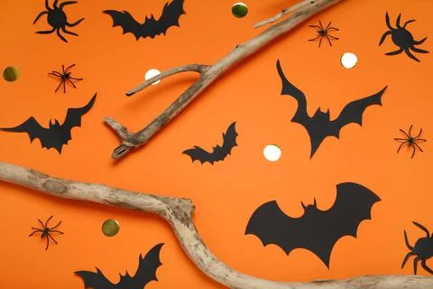 Flat lay composition with paper bats, spiders and wooden branches on orange b Stock Photos