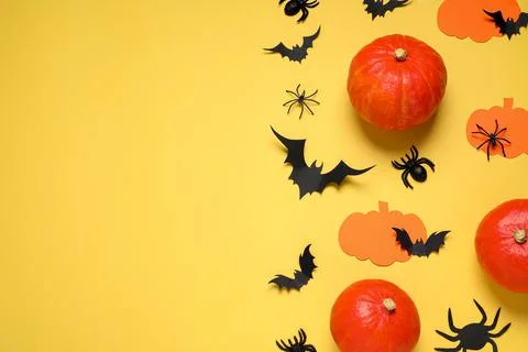 Flat lay composition with paper bats, pumpkins and spiders on yellow backgrou Stock Photos