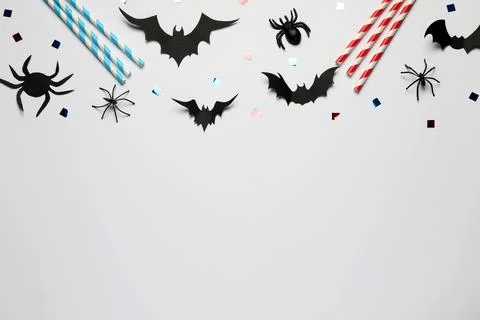 Flat lay composition with paper bats, spiders and straws on white background, Stock Photos