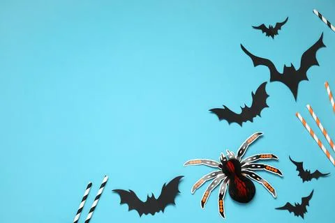 Flat lay composition with paper bats, spider and cocktail straws on light blu Stock Photos