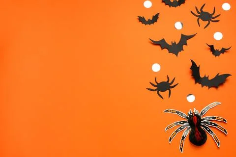 Flat lay composition with paper bats, spiders and golden confetti on orange b Stock Photos