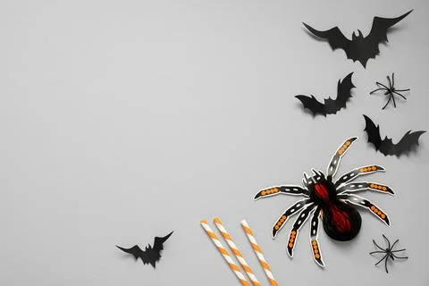 Flat lay composition with paper bats, spiders and cocktail straws on light gr Stock Photos