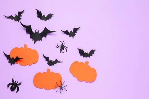 Flat lay composition with paper bats, spiders and pumpkins on light violet ba Stock Photos