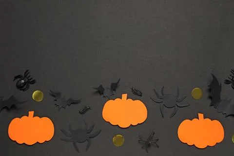 Flat lay composition with paper bats, pumpkins and spiders on black backgroun Stock Photos