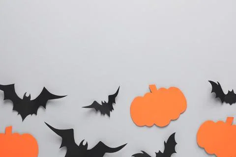 Flat lay composition with paper bats and pumpkins on light grey background, s Stock Photos