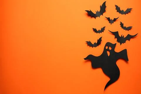 Flat lay composition with paper ghost and bats on orange background, space fo Stock Photos