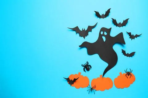 Flat lay composition with paper ghost, bats and pumpkins on light blue backgr Stock Photos