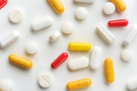 Flat lay composition with pills and capsules on a white background. Stock Photos