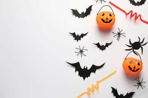 Flat lay composition with plastic pumpkin baskets and paper bats on white bac Stock Photos