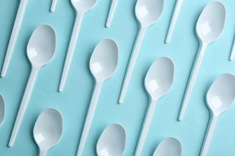 Flat lay composition with plastic spoons on color background. Table setting Stock Photos