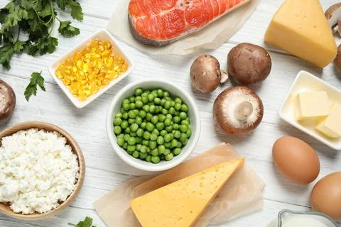 Flat lay composition with products rich in vitamin D on white wooden table Stock Photos