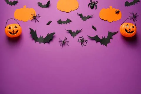 Flat lay composition with pumpkins, spiders and paper bats on purple backgrou Stock Photos