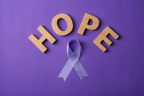 Flat lay composition with purple ribbon and word HOPE on violet background. D Stock Photos