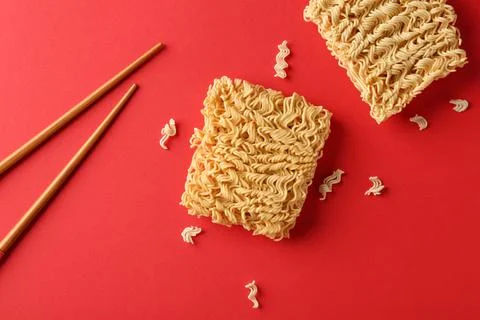 Flat lay composition with quick cooking noodles and chopsticks on color backg Stock Photos