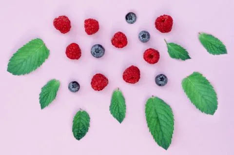 Flat lay composition of raspberries and blueberries on a pink background and  Stock Photos