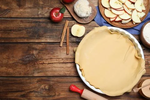 Flat lay composition with raw dough and ingredients on wooden table, space fo 写真素材