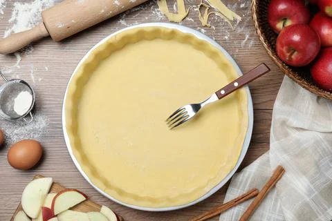 Flat lay composition with raw dough, fork and ingredients on wooden table. Ba 写真素材