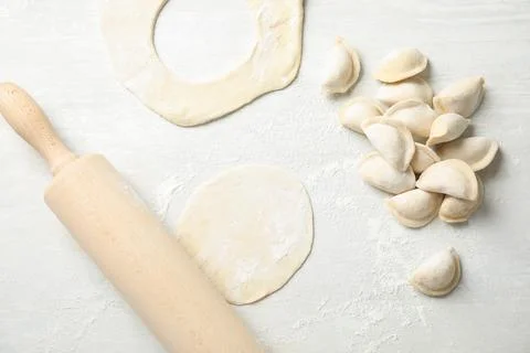 Flat lay composition with raw dumplings on light background. Process of cooki Foto stock
