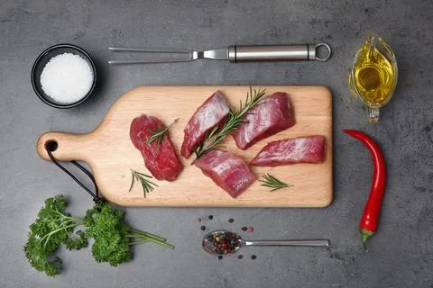 Flat lay composition with raw meat on grey background Stock Photos