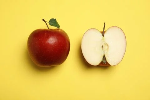 Flat lay composition with ripe juicy red apples on yellow background Stock Photos